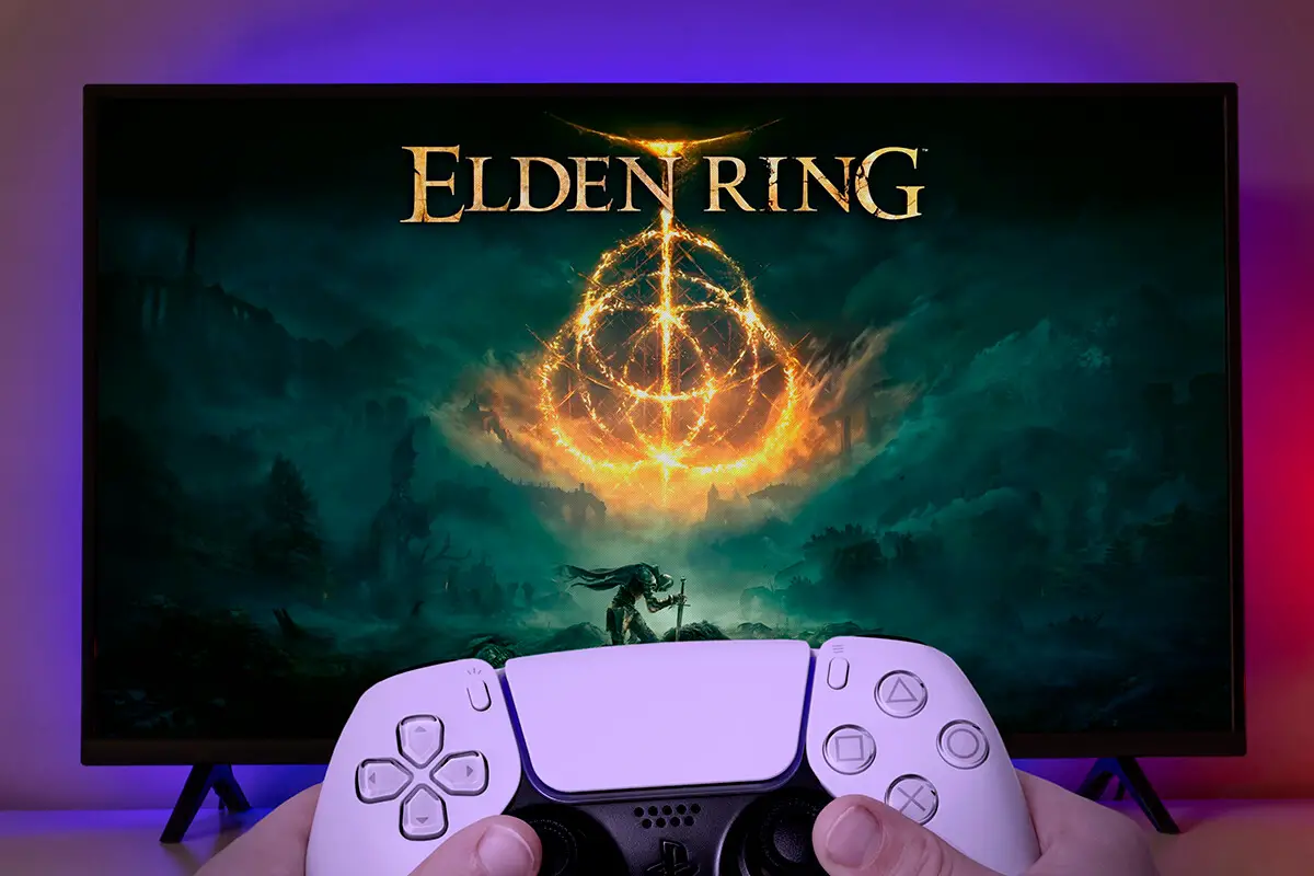 Kid hands with Playstation 5 controller playing Elden Ring at TV screen.