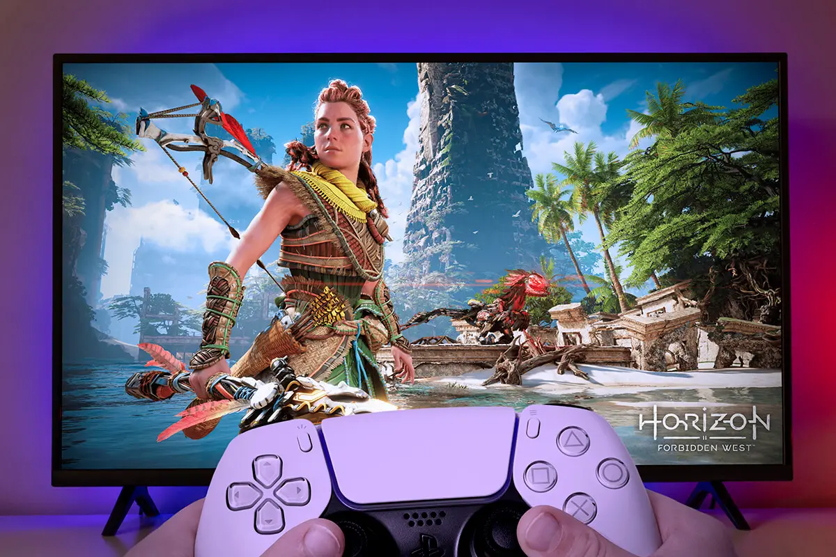 Boy playing Horizon Forbidden West with Playstation 5 controller.