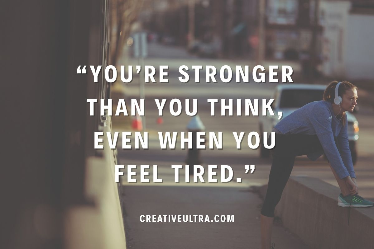 A woman in athletic wear leans on a ledge, listening to music with headphones. Motivational text reads, "You're stronger than you think, even when you feel tired." Urban background.